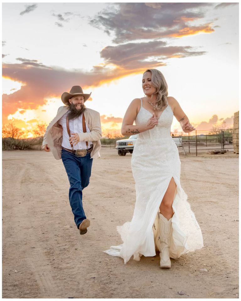 Bride in cowboy boots and groom in cowboy hat running at sunset at Cocoraque Ranch in Tucson