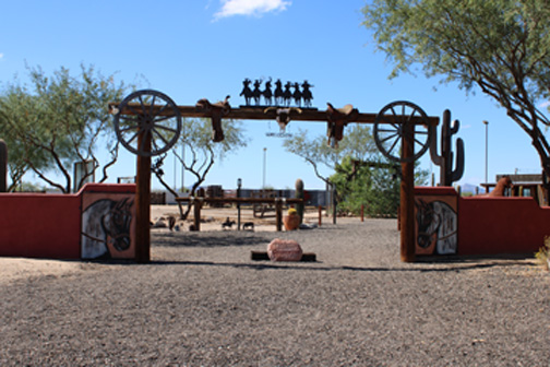 Cocoraque Ranch entrance gate with adobe walls and wagon-wheel accents in Tucson
