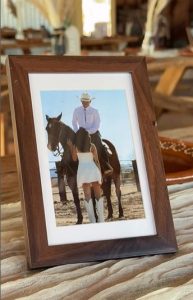 Framed photo of a cowboy on horseback and a bride in a white dress and boots at Cocoraque Ranch, a rustic wedding venue near Tucson.
