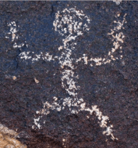 Human figure petroglyph etched into dark rock at Cocoraque Butte near Tucson